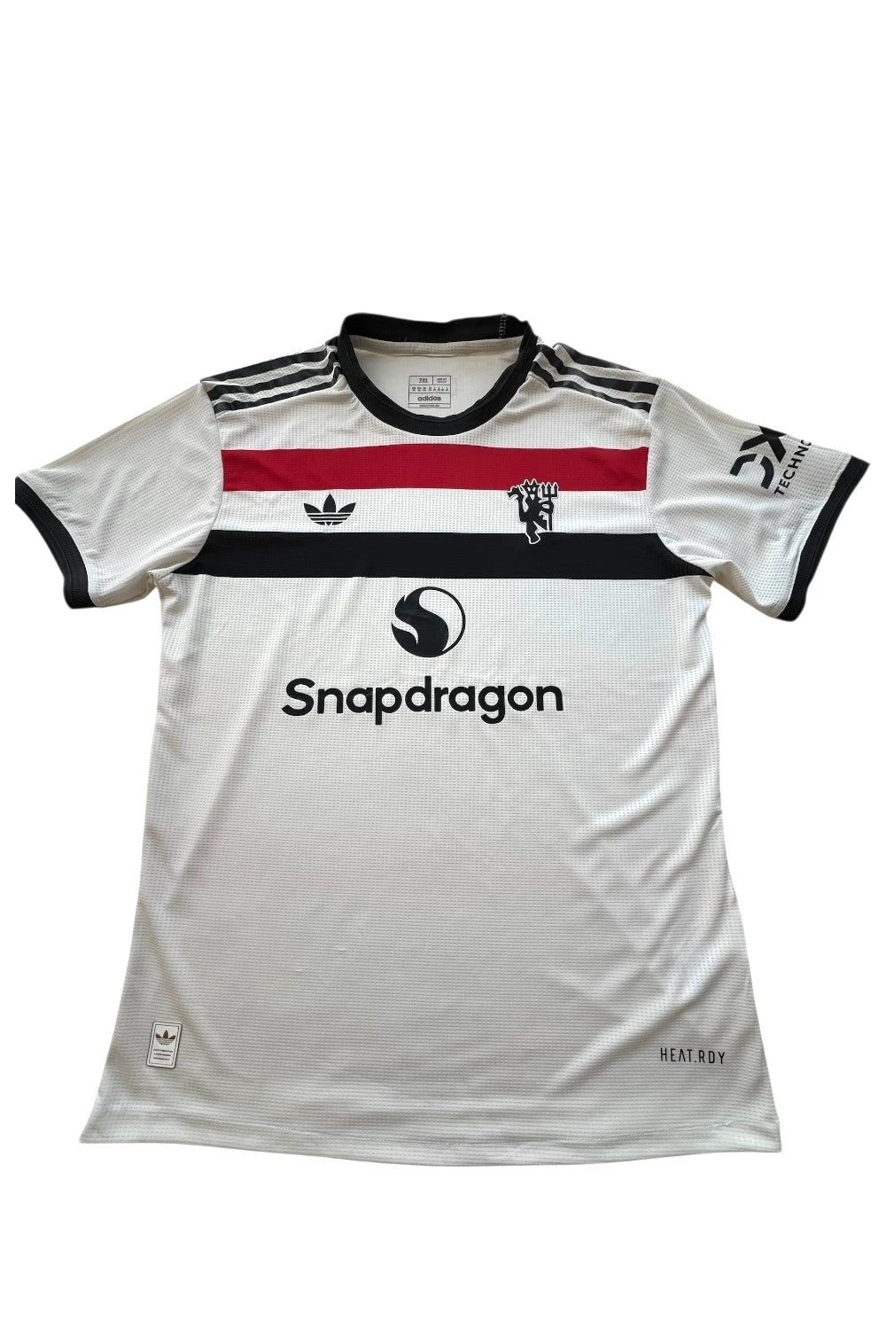 Adidas white graphic tee Manchester United logo, 100% polyester, sporty design.