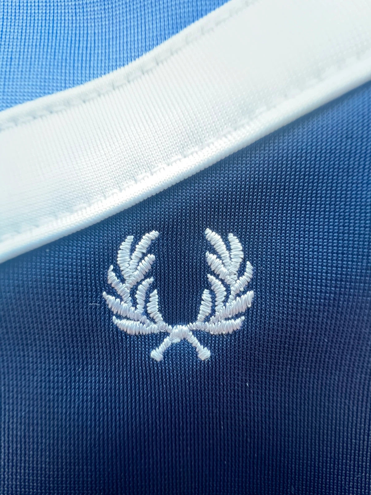 Fred Perry blue Y2K sporty jacket with logo detail and vintage track design.