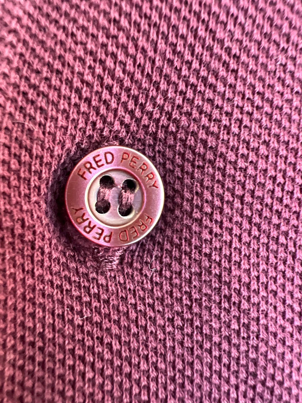 Fred Perry purple long sleeve polo shirt with classic logo and pique texture.