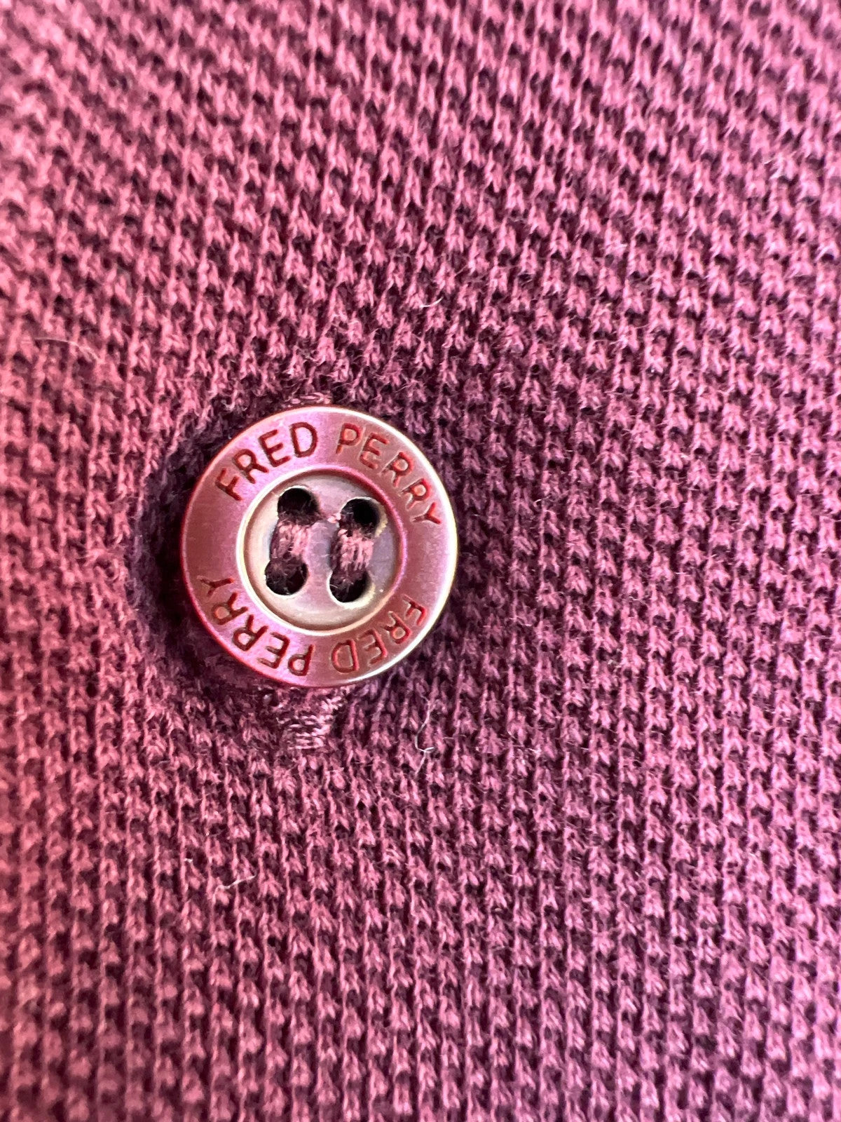 Fred Perry purple long sleeve polo shirt with classic logo and pique texture.