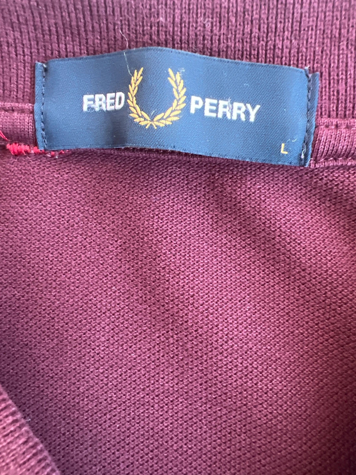 Fred Perry purple long sleeve polo shirt with classic logo and pique texture.