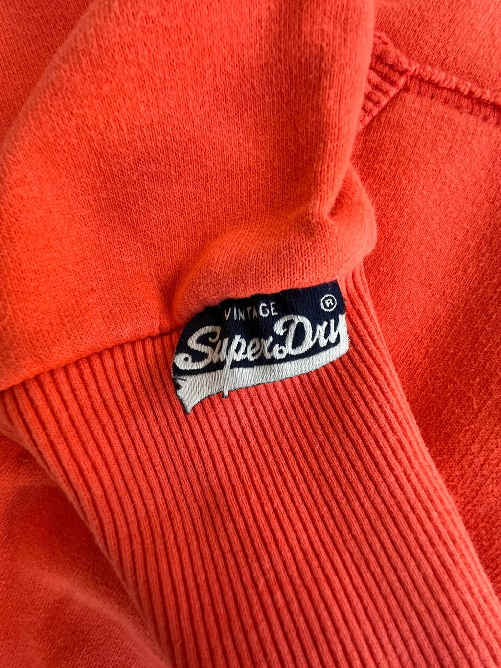 Superdry orange oversized hoodie with large vintage logo and casual streetwear style.
