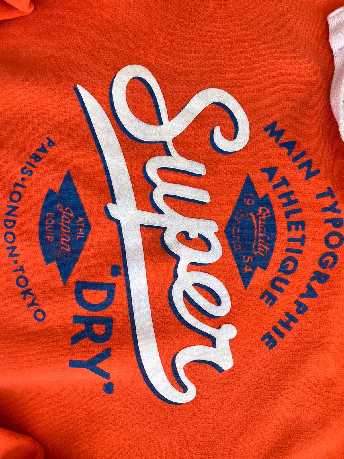Superdry orange oversized hoodie with large vintage logo and casual streetwear style.