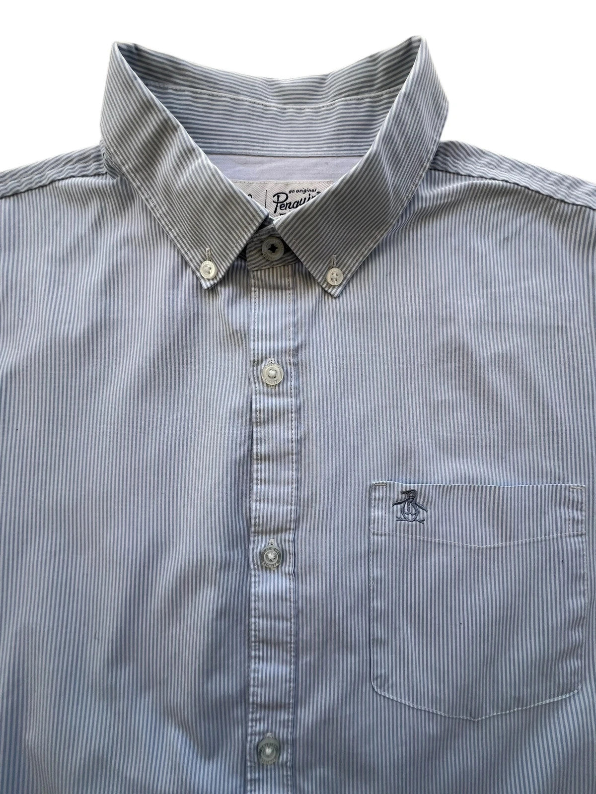 Penguin blue and white striped button down shirt with casual collar and subtle imperfections.