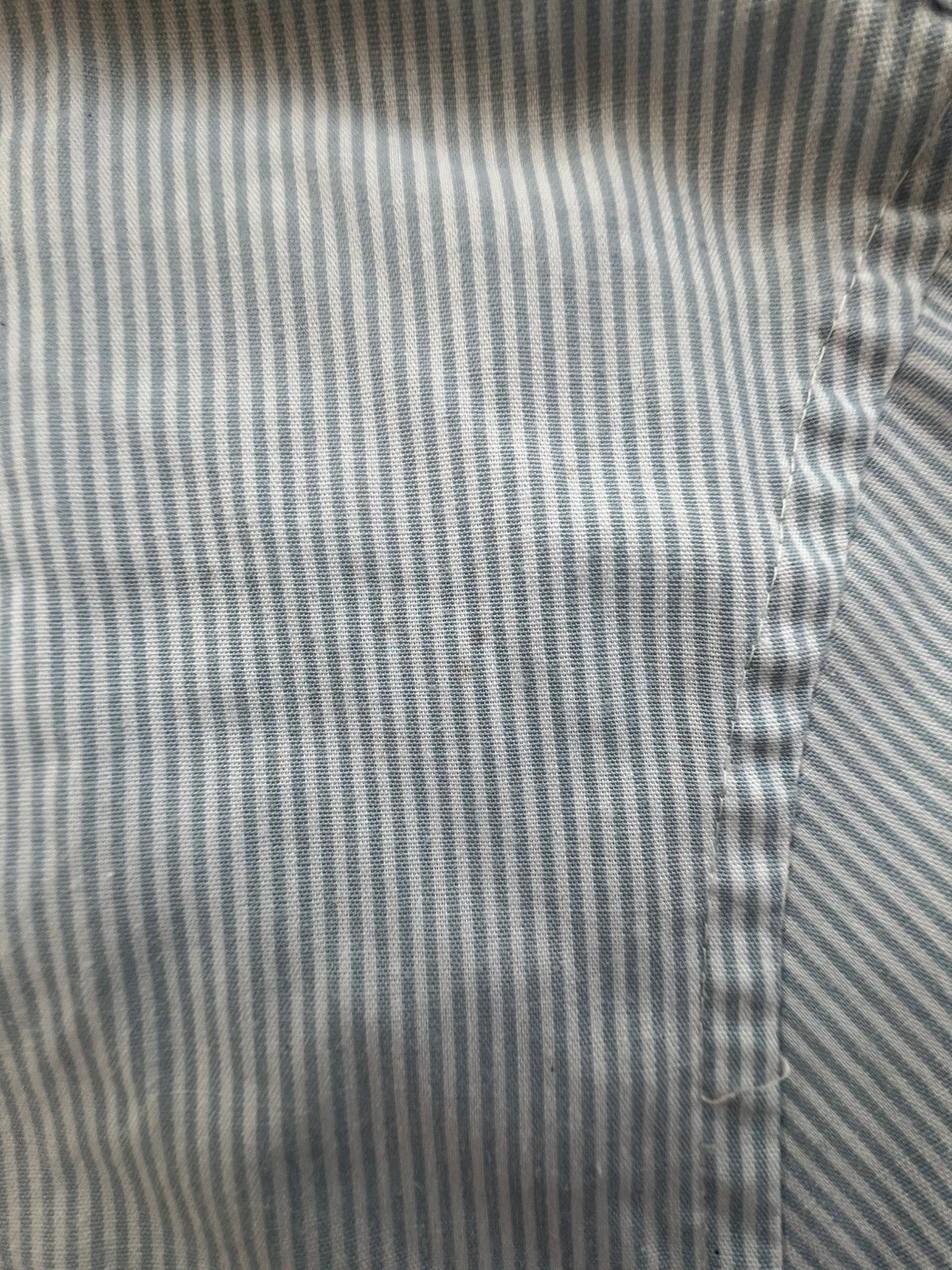 Penguin blue and white striped button down shirt with casual collar and subtle imperfections.