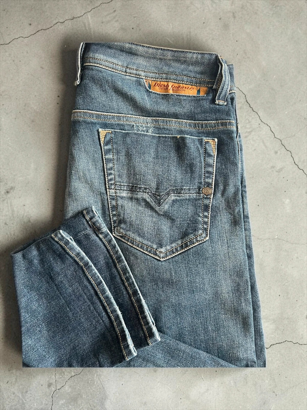Diesel blue slim straight jeans with logo patch and classic denim texture.