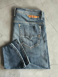 Diesel blue slim straight jeans with logo patch and classic denim texture.