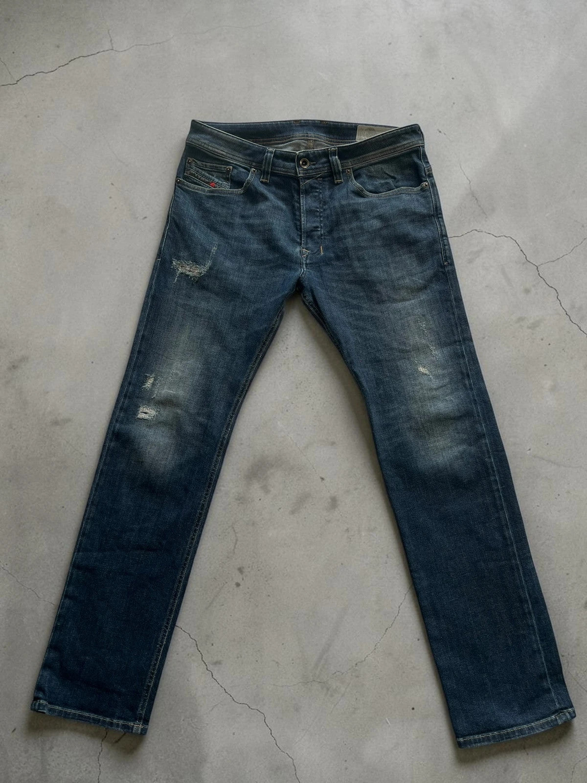 Diesel blue slim straight jeans with logo patch and classic denim texture.