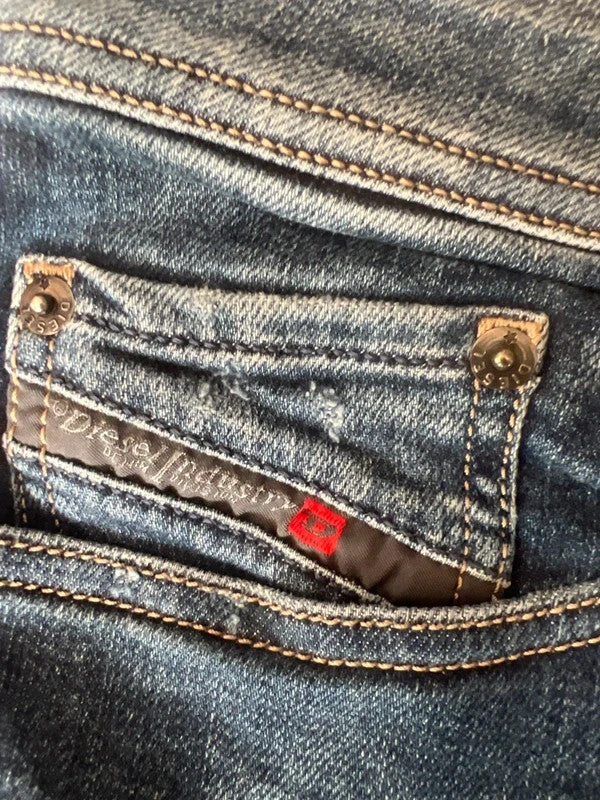 Diesel blue slim straight jeans with logo patch and classic denim texture.