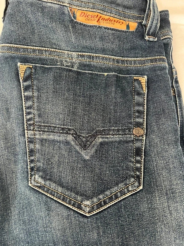 Diesel blue slim straight jeans with logo patch and classic denim texture.