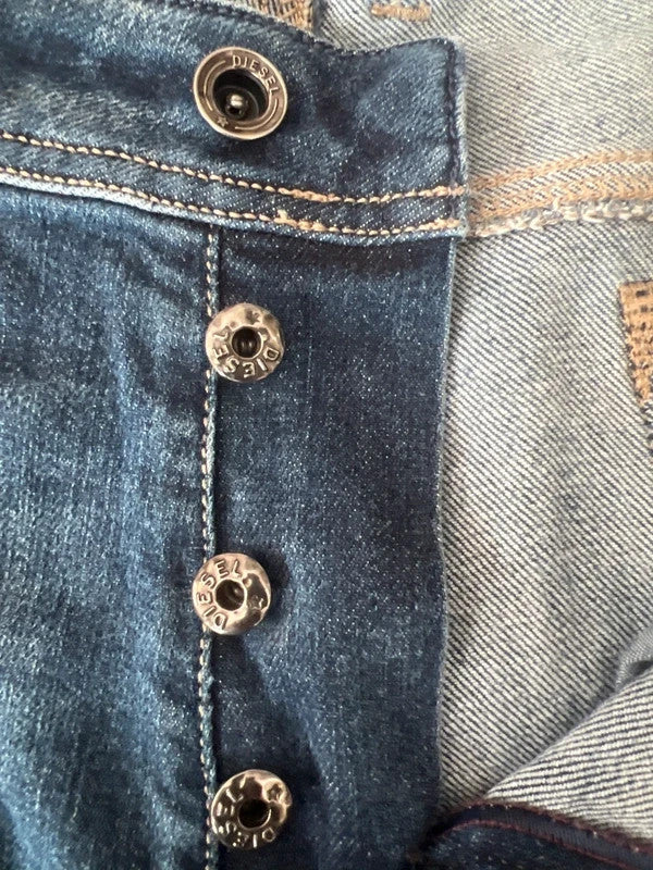 Diesel blue slim straight jeans with logo patch and classic denim texture.