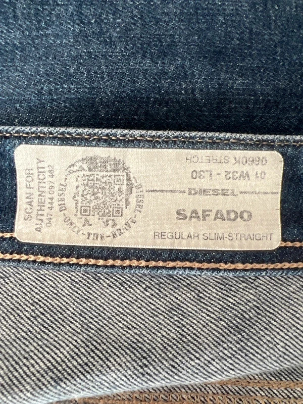Diesel blue slim straight jeans with logo patch and classic denim texture.