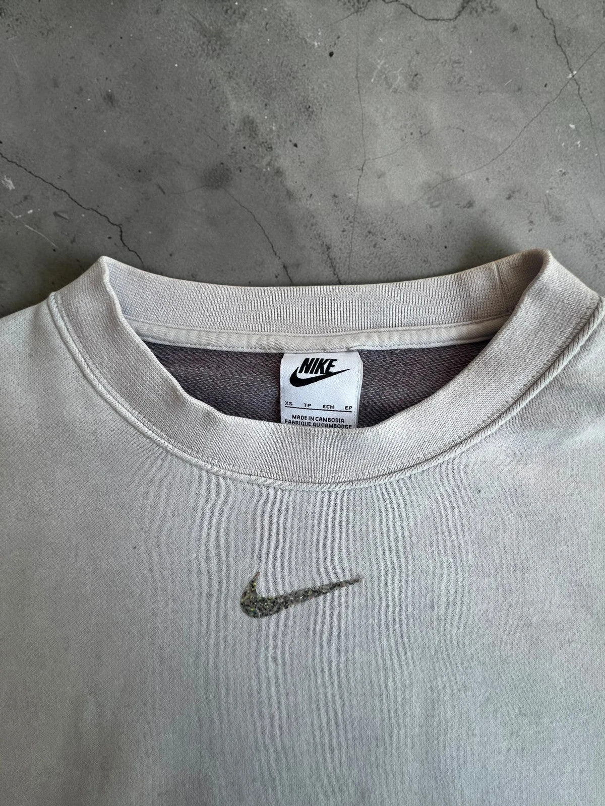 Nike cream cropped sweatshirt with embroidered mini swoosh logo, oversized fit.