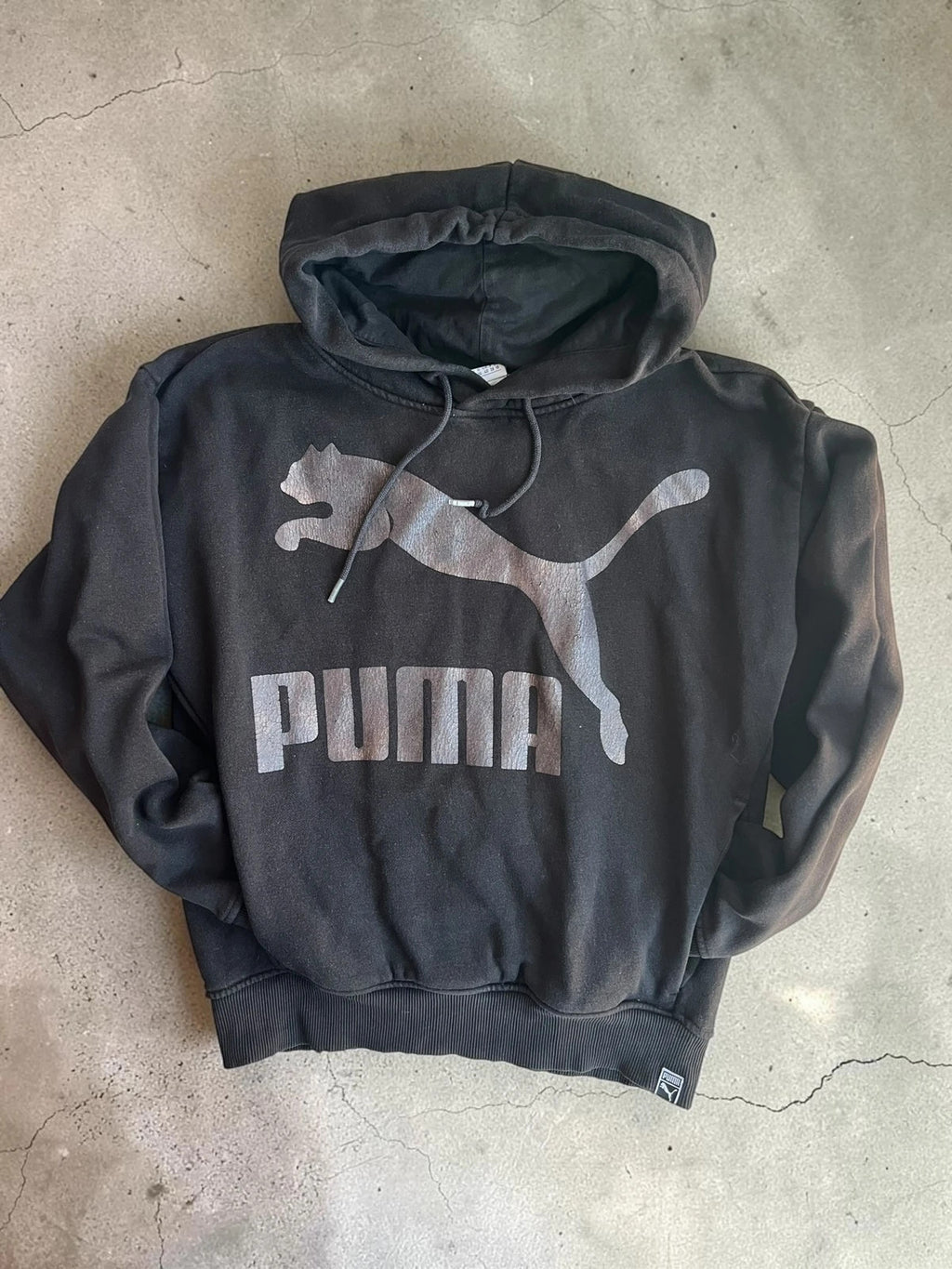 Puma black oversized hoodie with large cracked silver logo, vintage Y2K style.