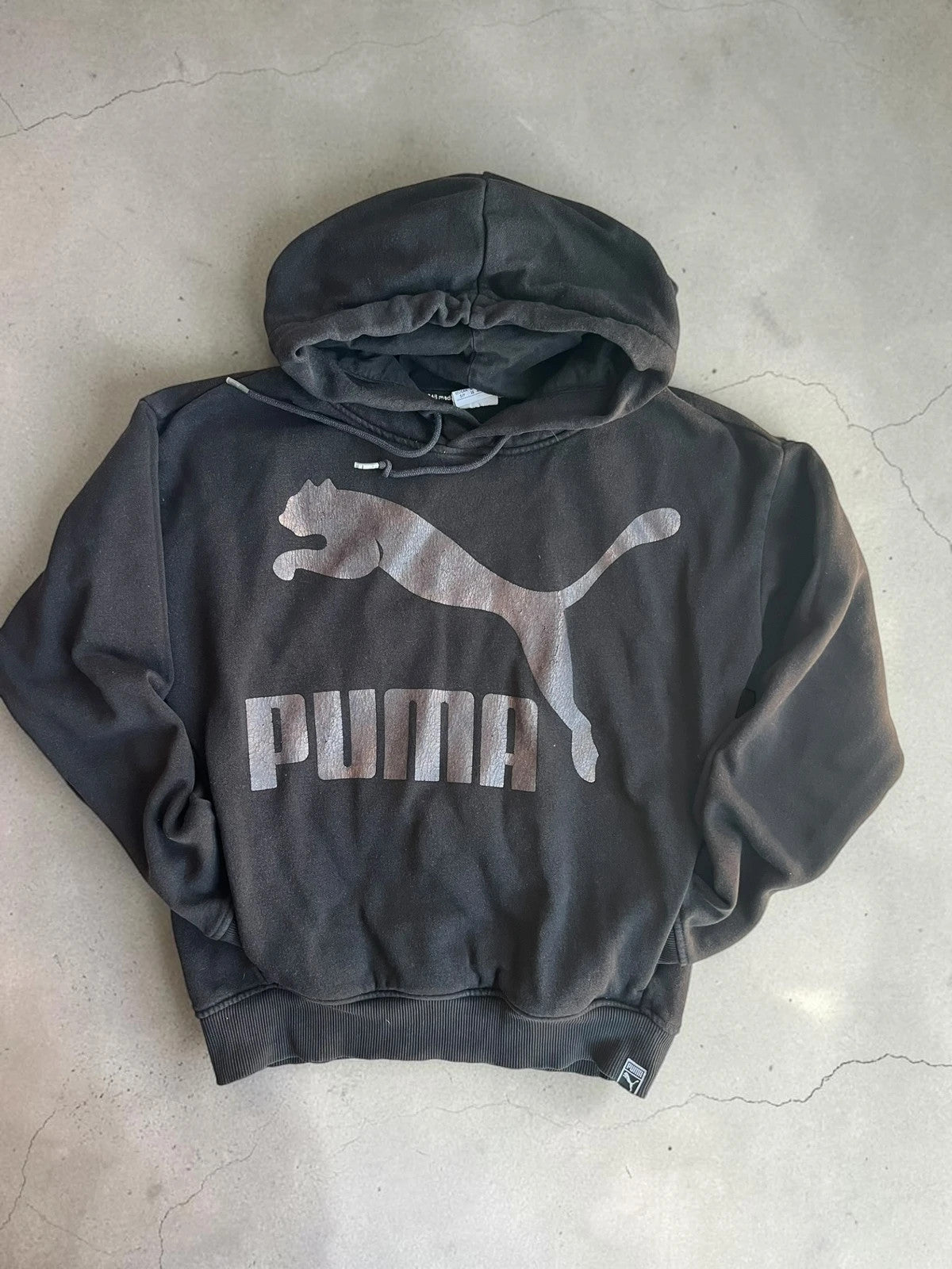 Puma black oversized hoodie with large cracked silver logo, vintage Y2K style.