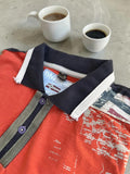 Napapijri orange long sleeve polo with embroidered patches and "Forever Wild and Free" graphic.