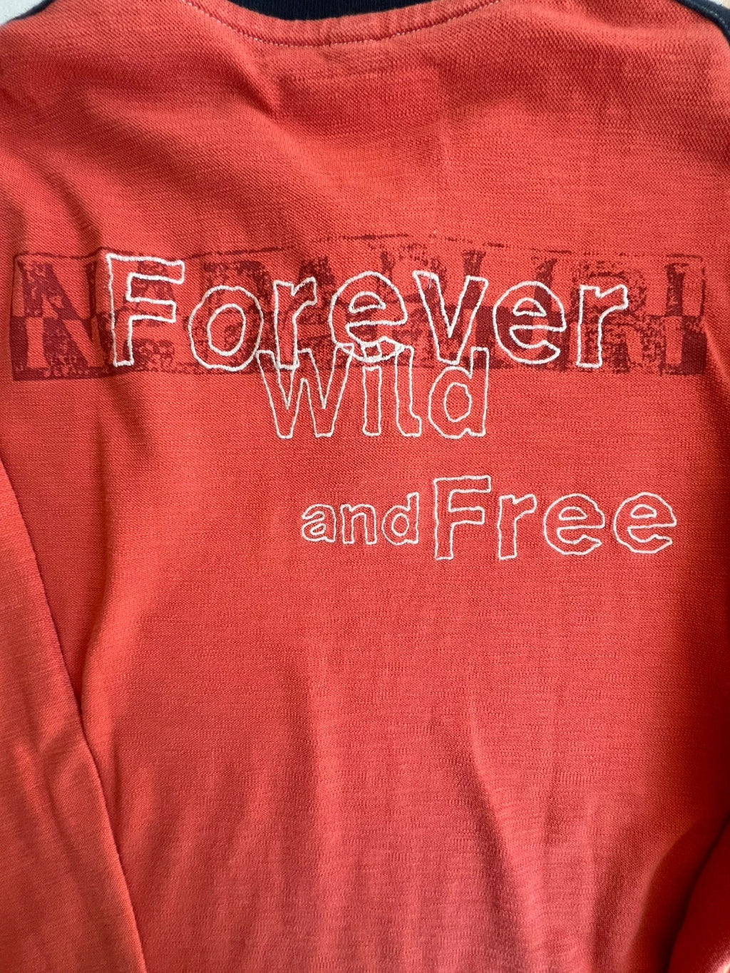 Napapijri orange long sleeve polo with embroidered patches and "Forever Wild and Free" graphic.