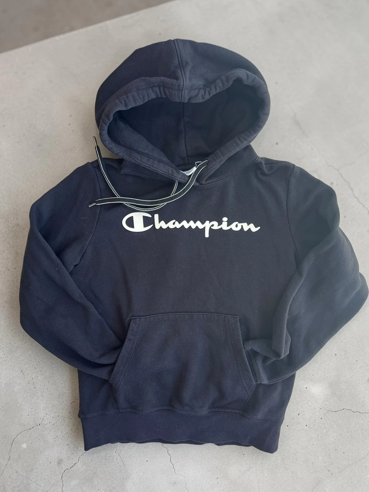 Champion black hoodie large spell out logo front, kangaroo pocket, fleece interior.