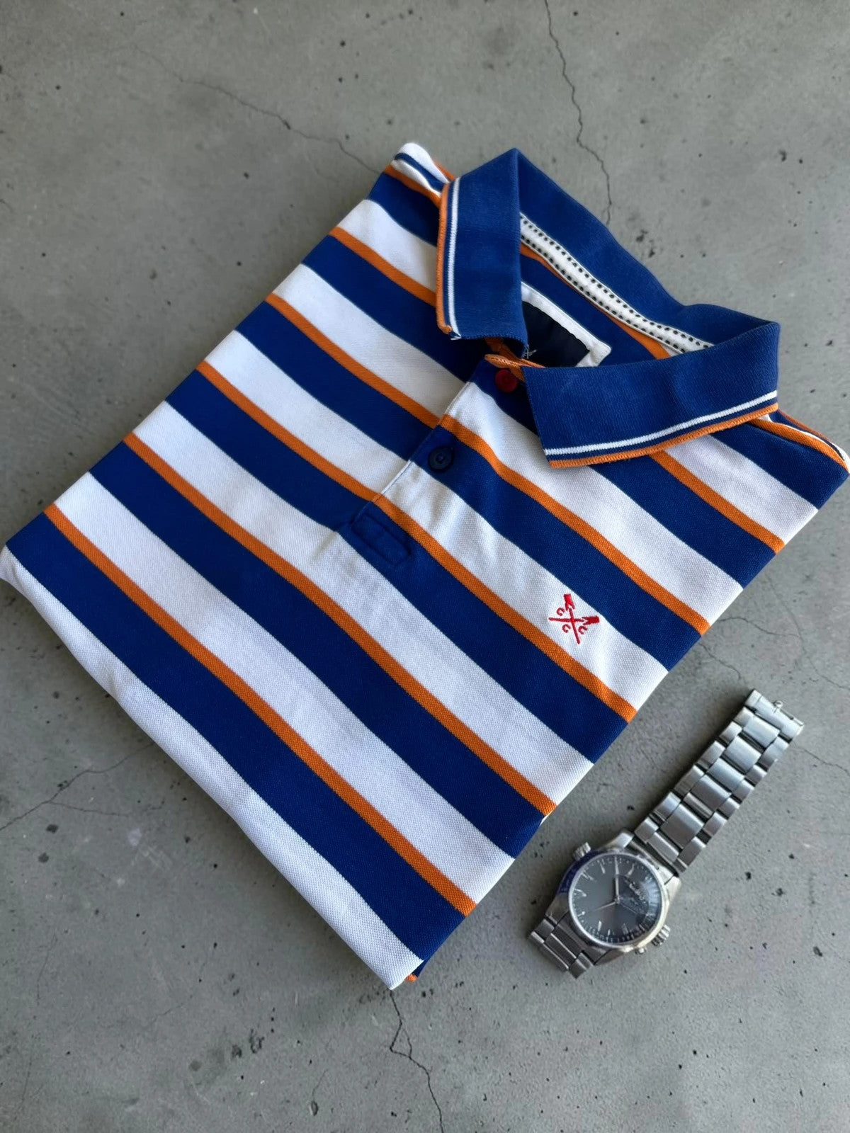CCC men's polo shirt blue and white striped with orange accents, 100% cotton.