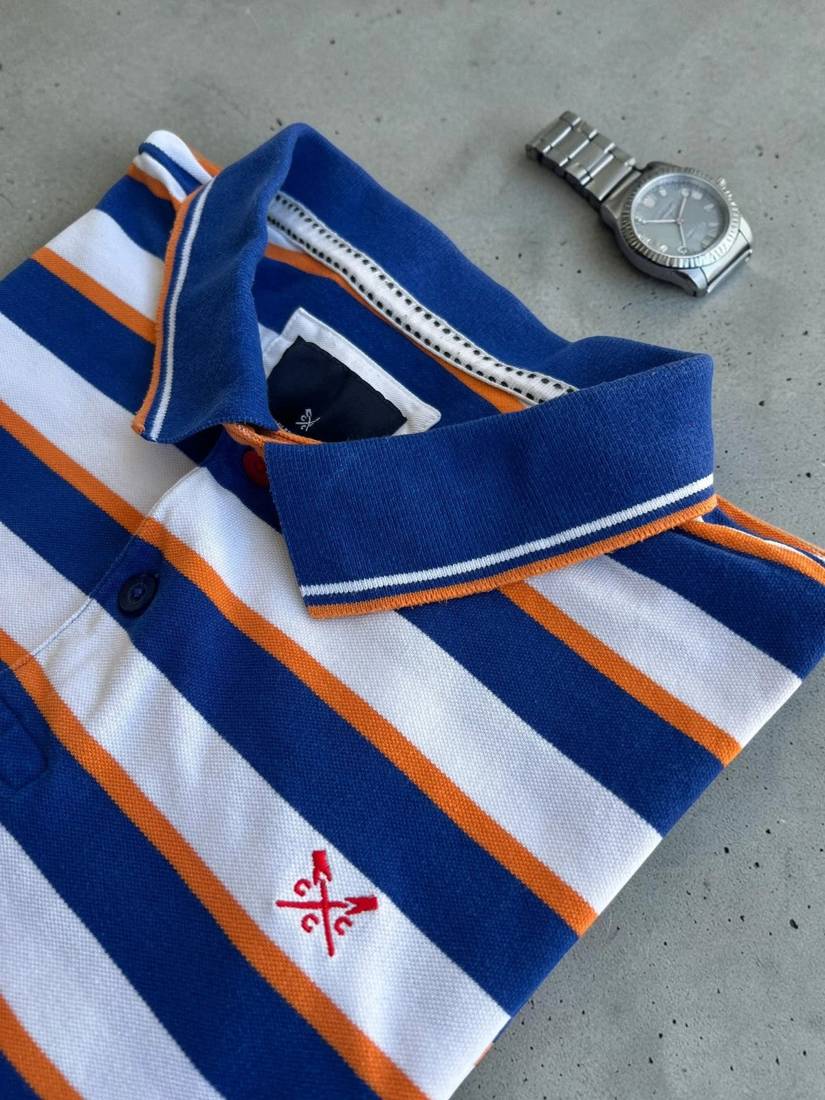 CCC men's polo shirt blue and white striped with orange accents, 100% cotton.