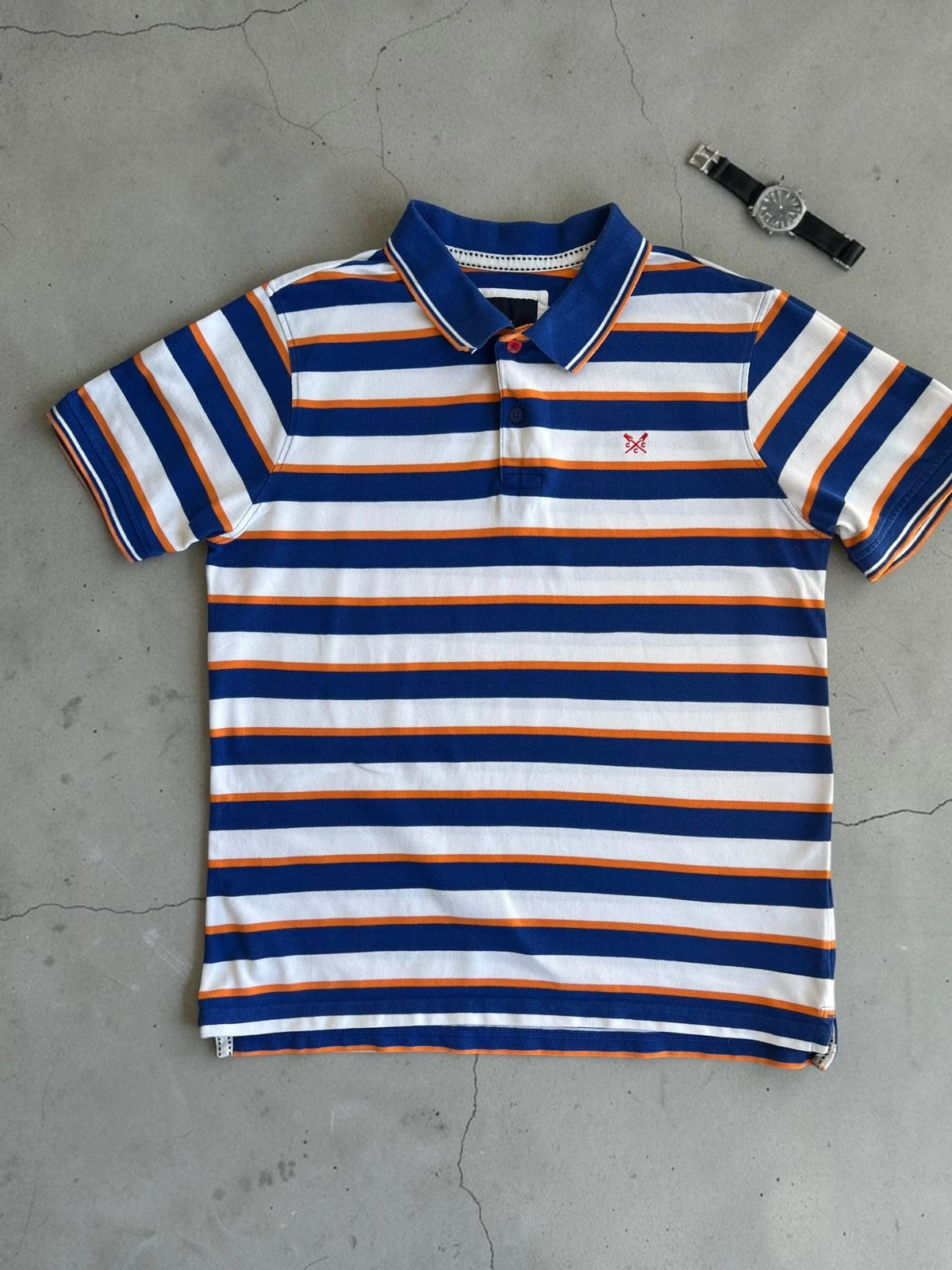 CCC men's polo shirt blue and white striped with orange accents, 100% cotton.