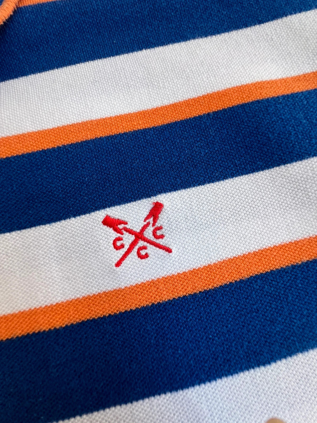 CCC men's polo shirt blue and white striped with orange accents, 100% cotton.