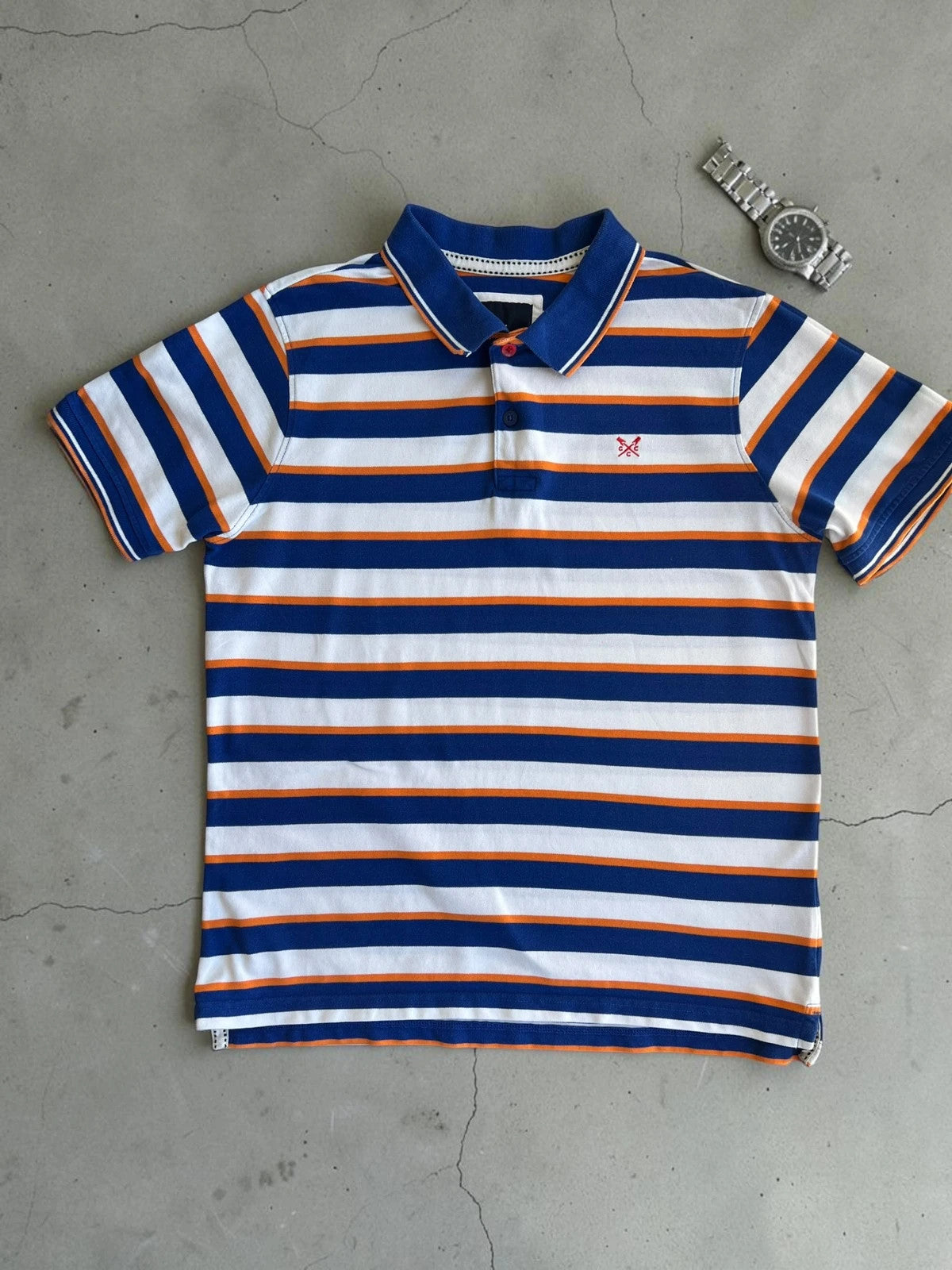 CCC men's polo shirt blue and white striped with orange accents, 100% cotton.