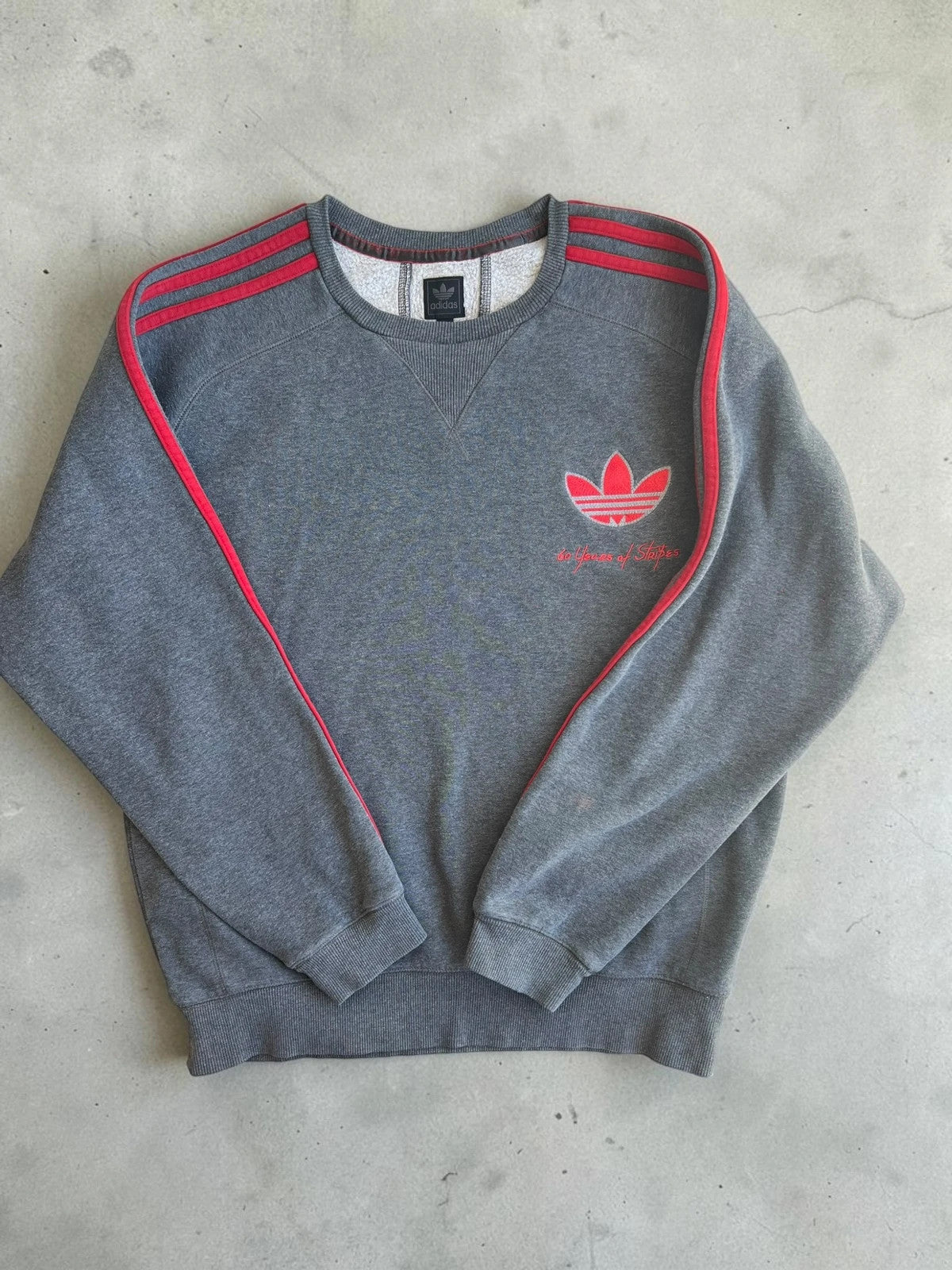 Adidas Originals grey sweatshirt with red details, embroidered Trefoil logo and decorative zipper.