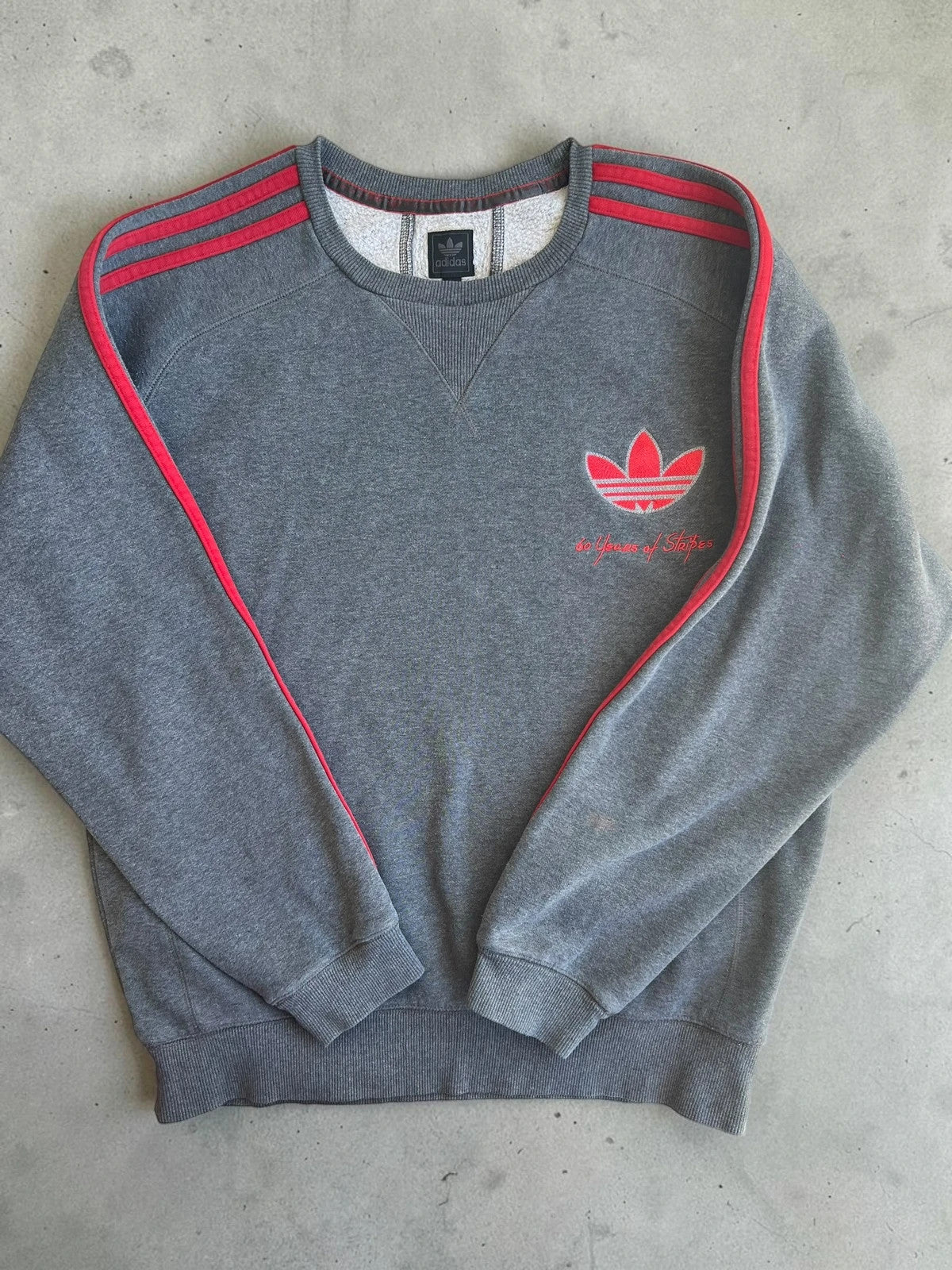 Adidas Originals grey sweatshirt with red details, embroidered Trefoil logo and decorative zipper.
