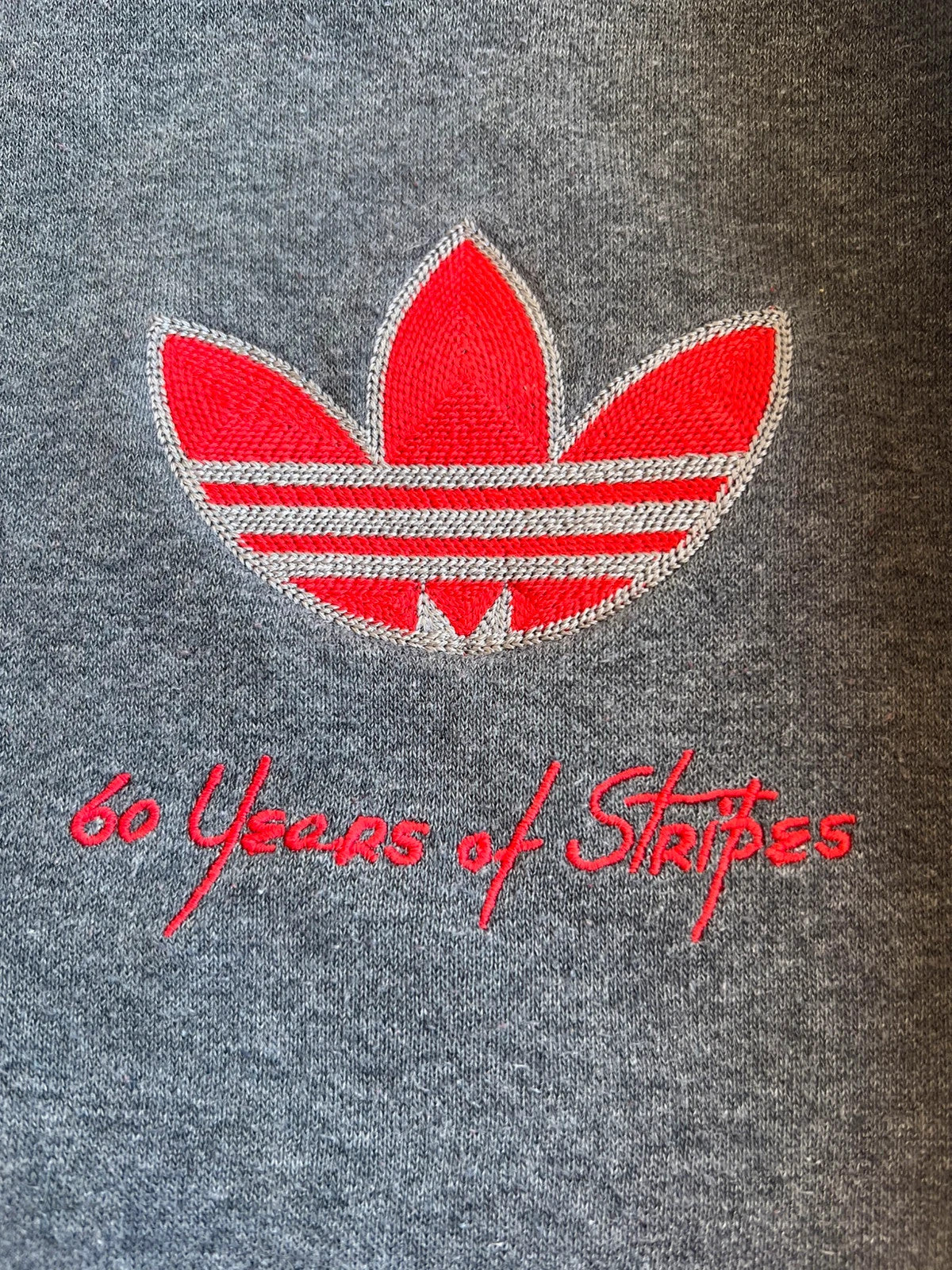 Adidas Originals grey sweatshirt with red details, embroidered Trefoil logo and decorative zipper.