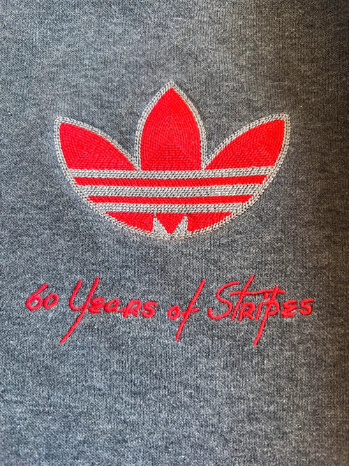 Adidas Originals grey sweatshirt with red details, embroidered Trefoil logo and decorative zipper.