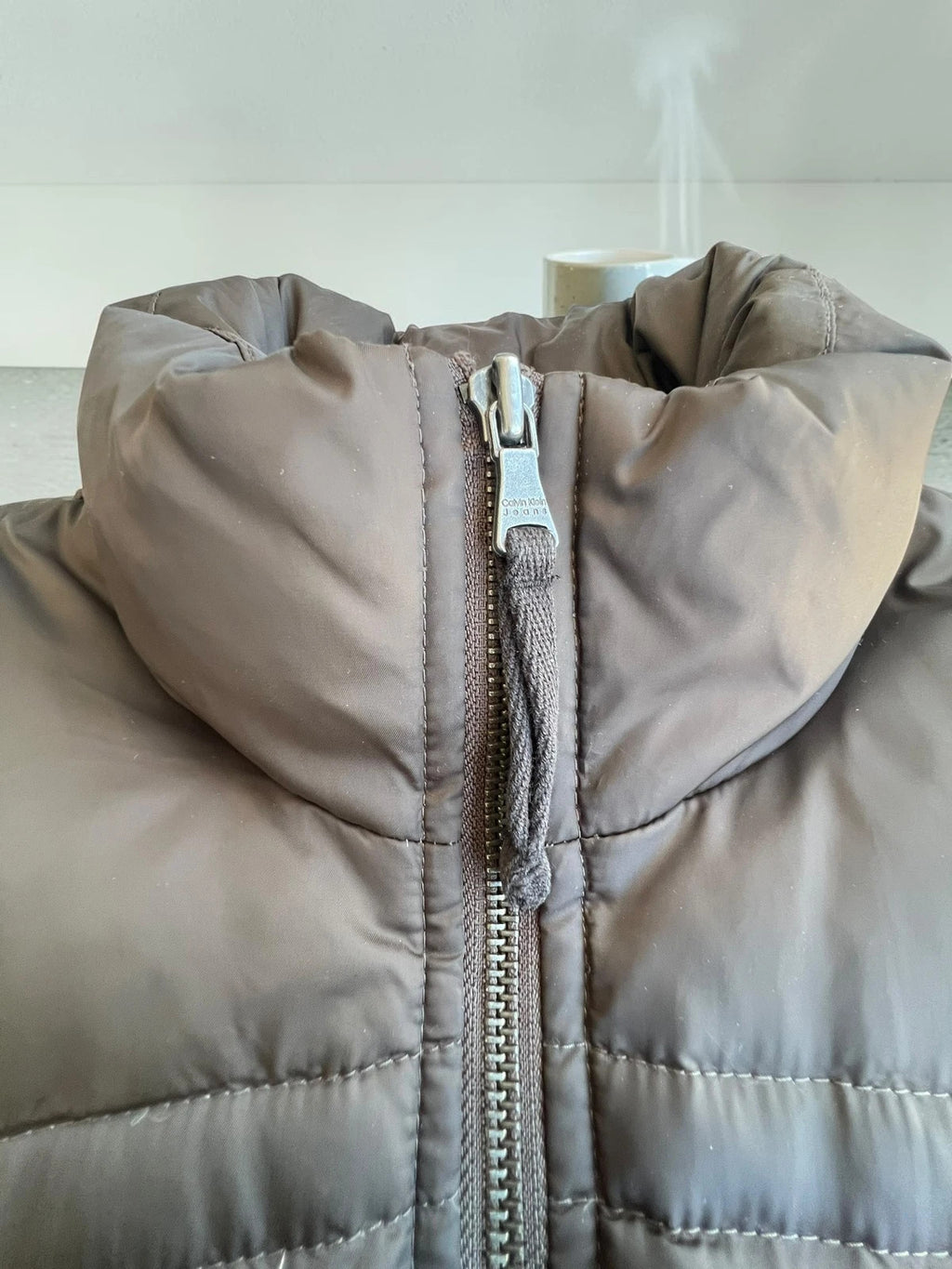 Calvin Klein brown puffer vest with duck down filling and logo detail.