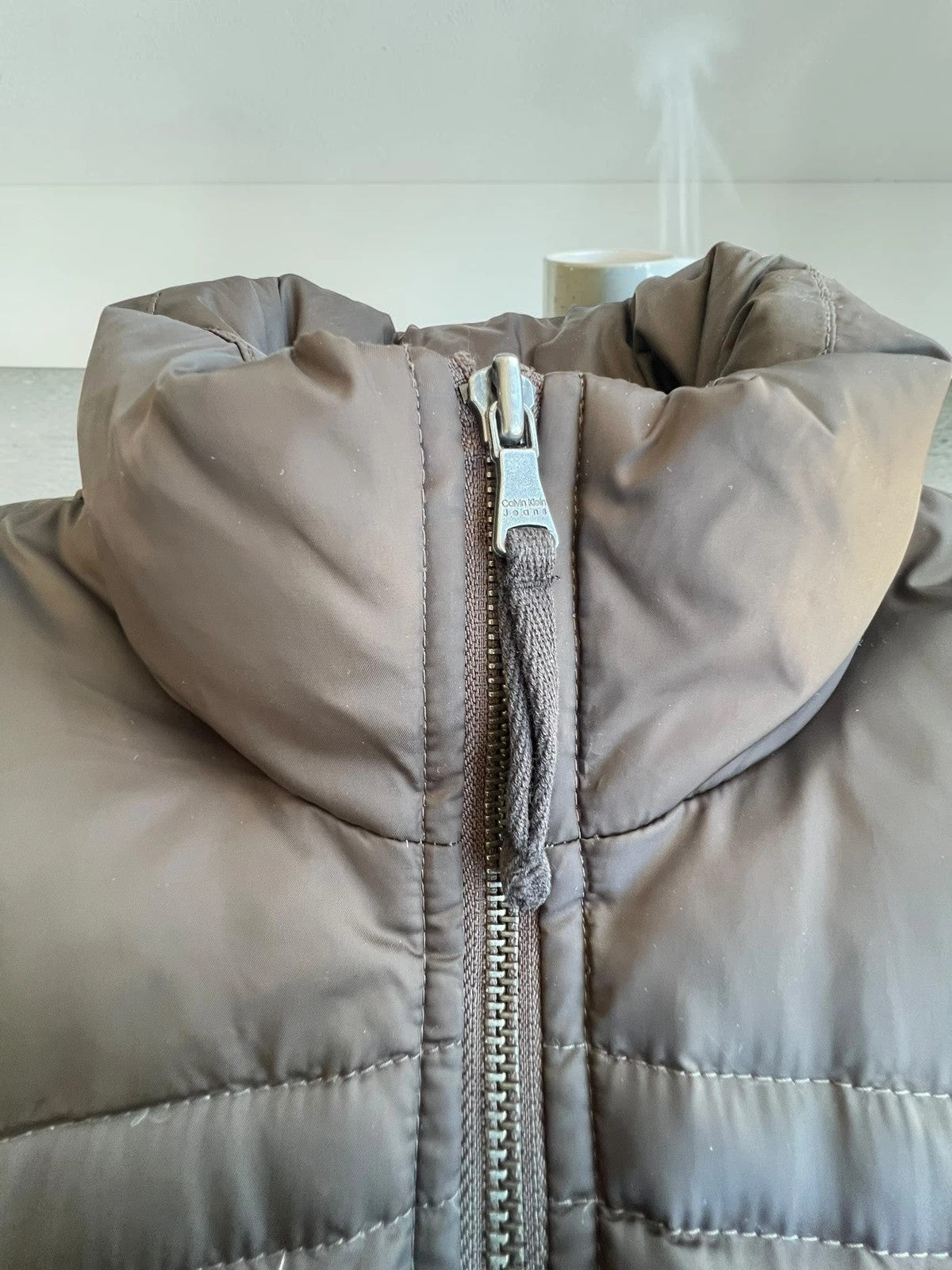 Calvin Klein brown puffer vest with duck down filling and logo detail.