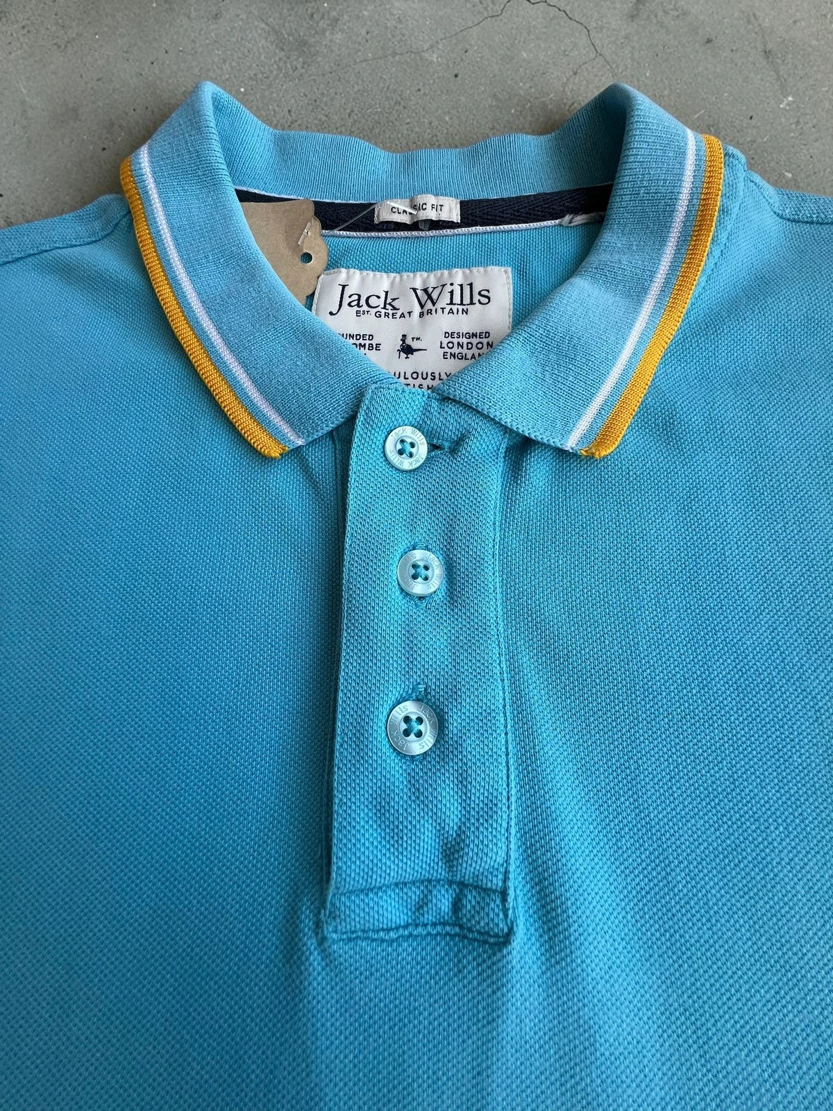 Jack Wills blue polo shirt with yellow collar and sleeve details, classic fit cotton.