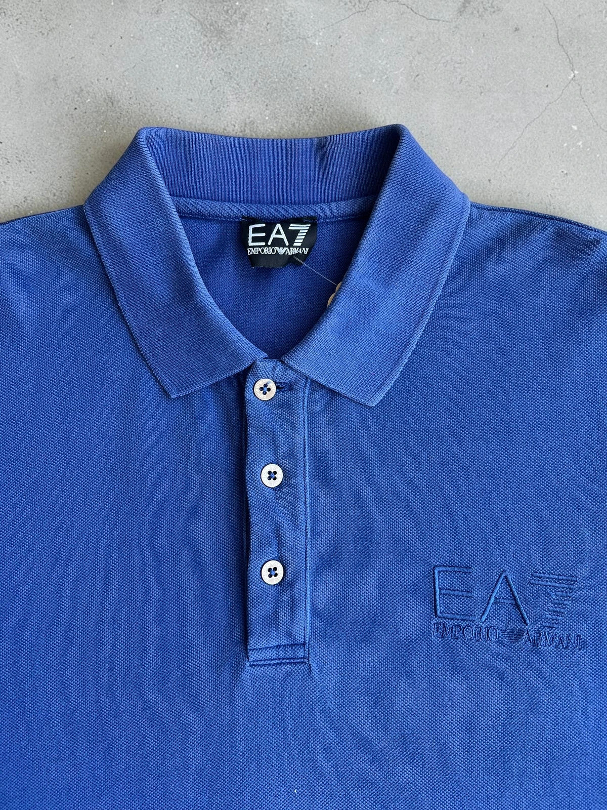 EA7 Emporio Armani blue polo shirt with embroidered logo and classic sporty design.
