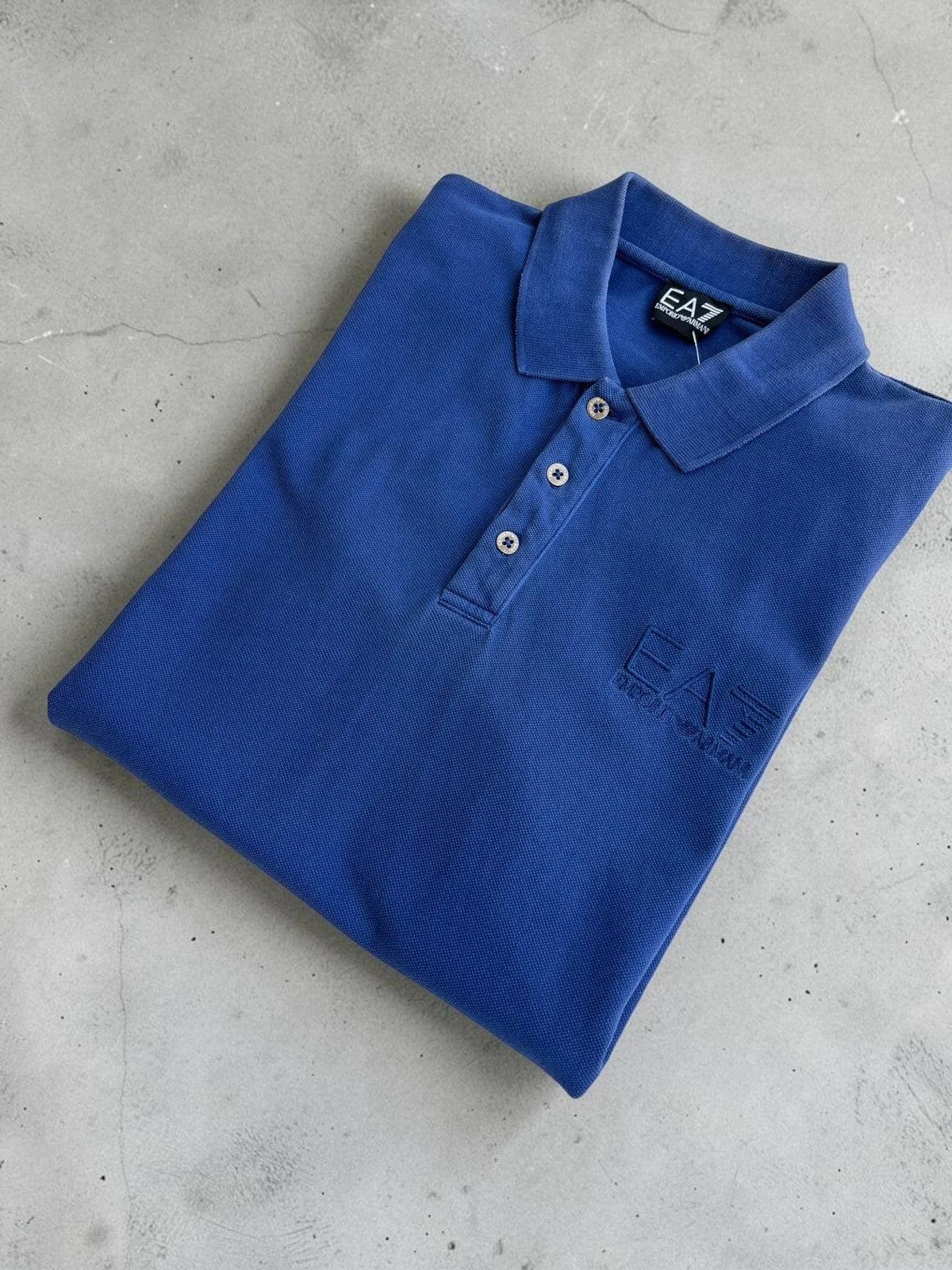 EA7 Emporio Armani blue polo shirt with embroidered logo and classic sporty design.