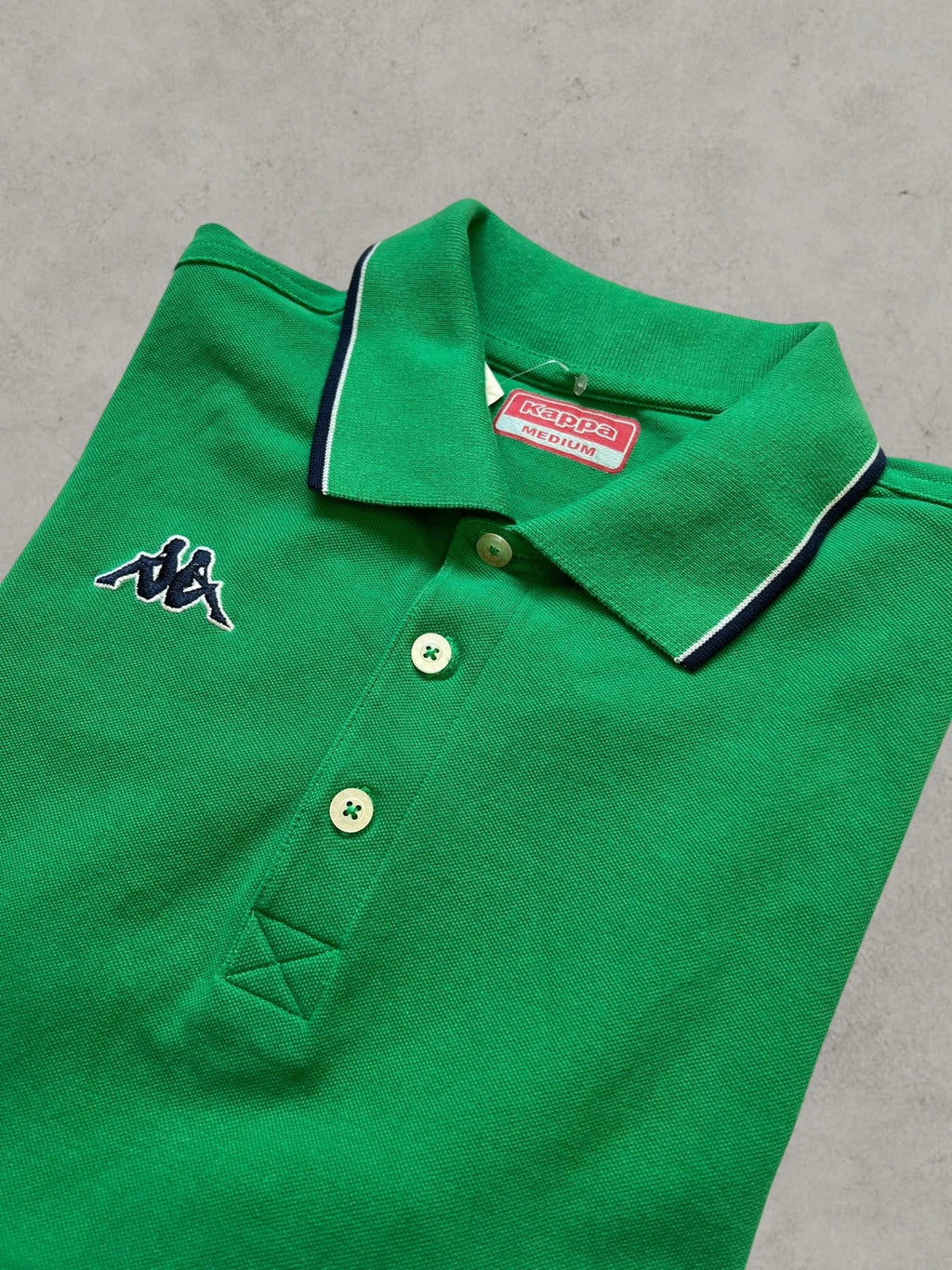 Kappa green polo shirt with embroidered logo and navy-white collar trim.