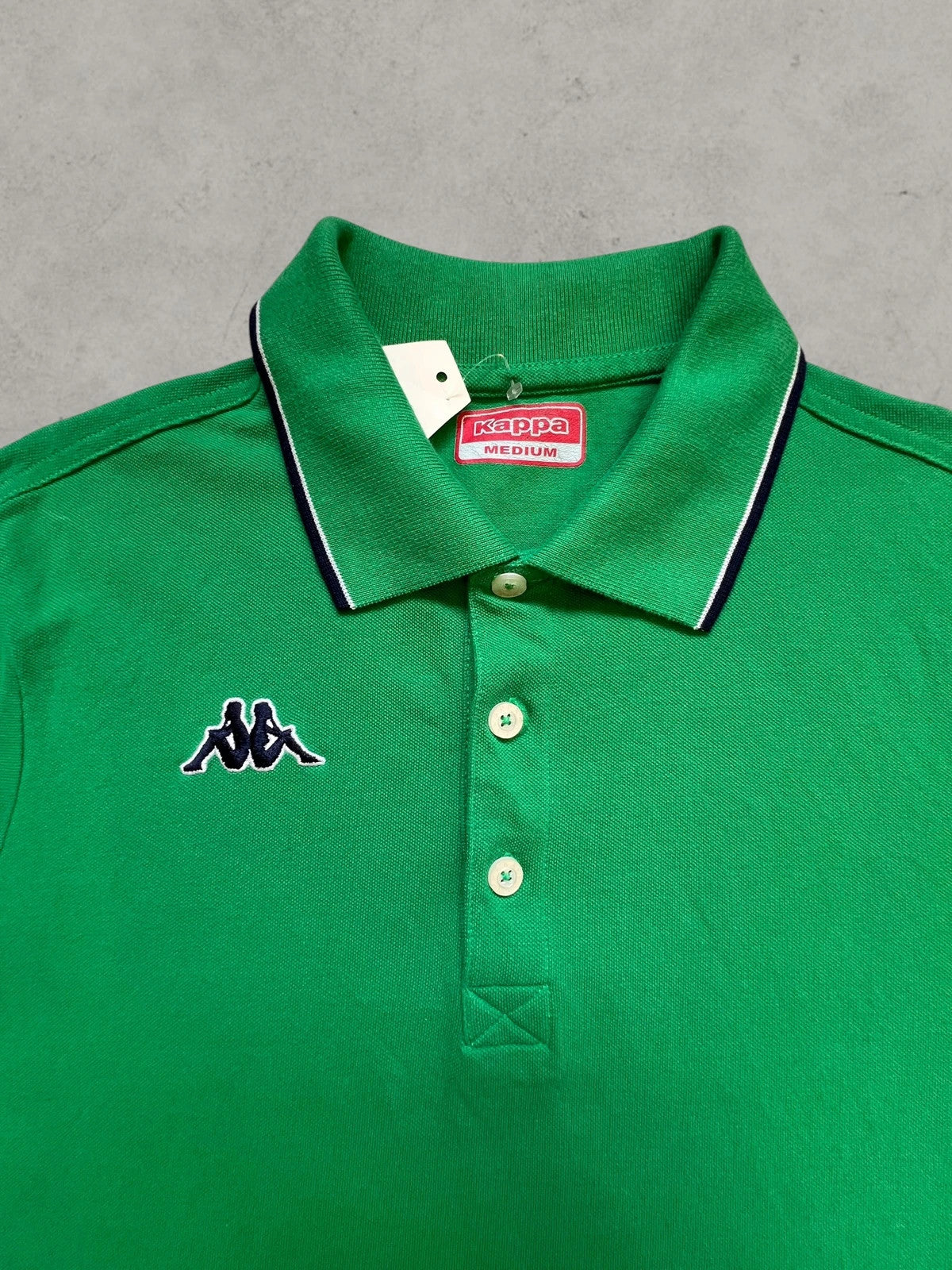 Kappa green polo shirt with embroidered logo and navy-white collar trim.