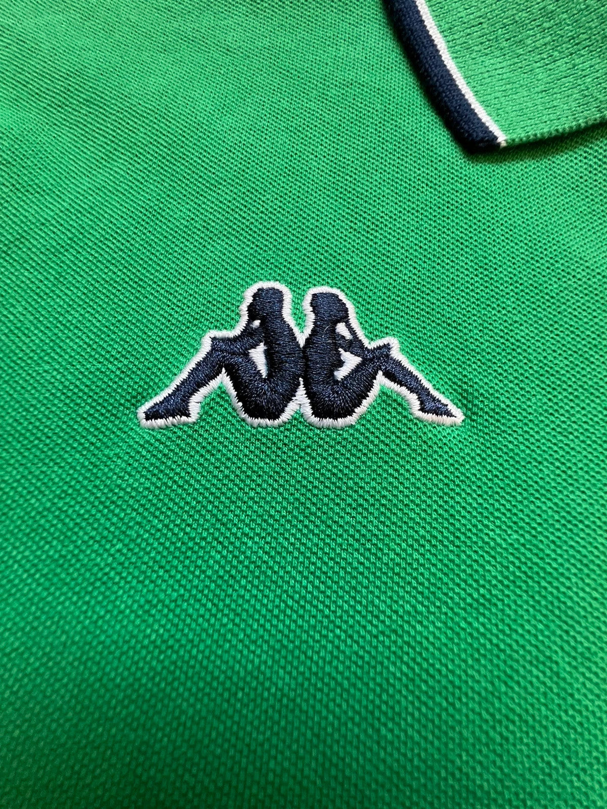 Kappa green polo shirt with embroidered logo and navy-white collar trim.