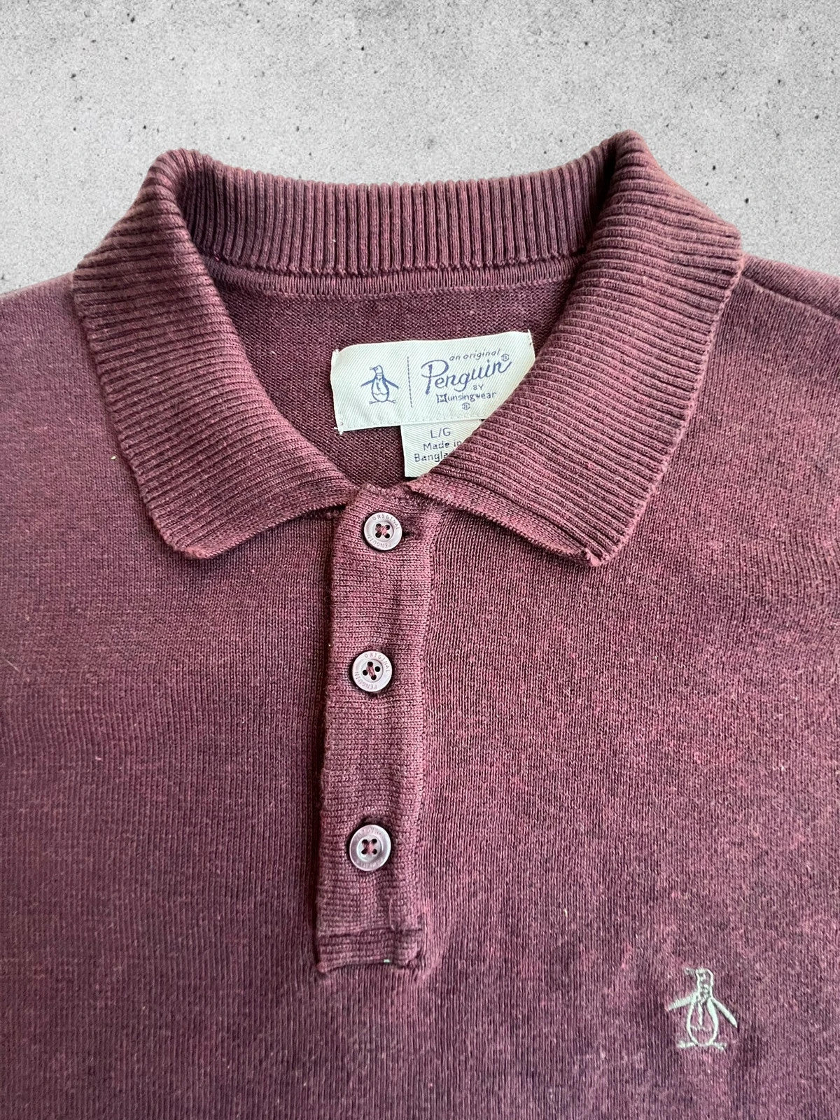 Penguin burgundy jersey polo with button closure and classic collar design.