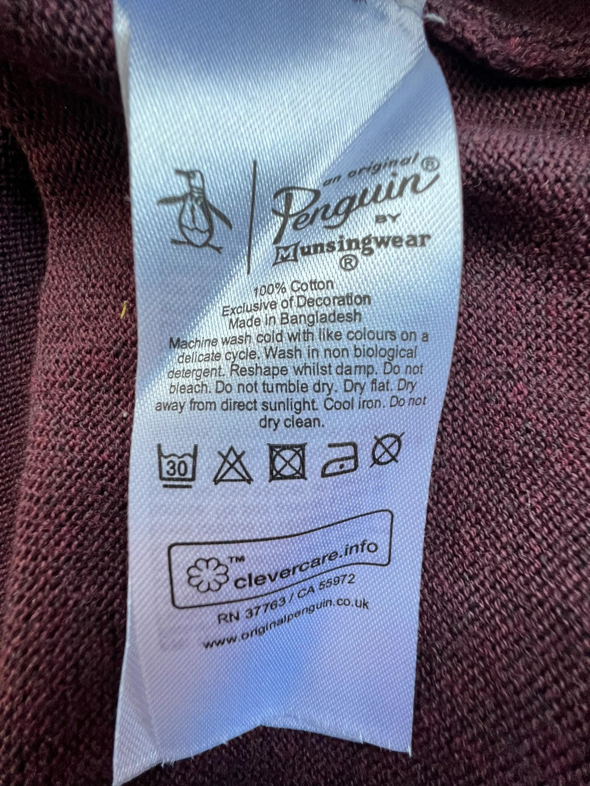 Penguin burgundy jersey polo with button closure and classic collar design.