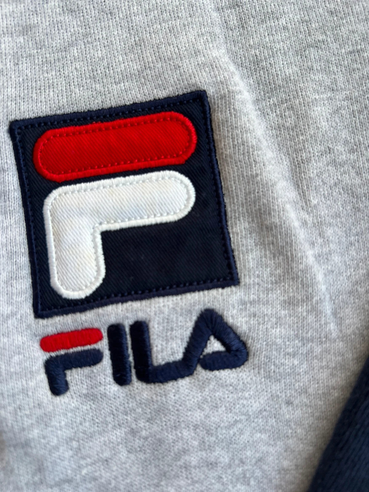 Fila navy sweatshirt with embroidered logo and side branding tapes, 90s retro style.