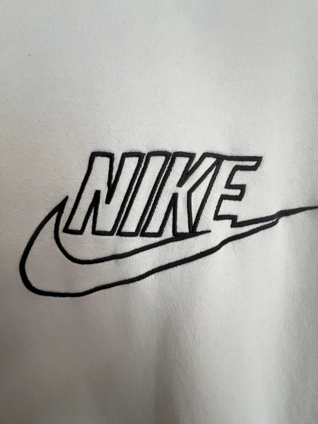 Nike white sweatshirt with beige embroidered logo and fleece interior.