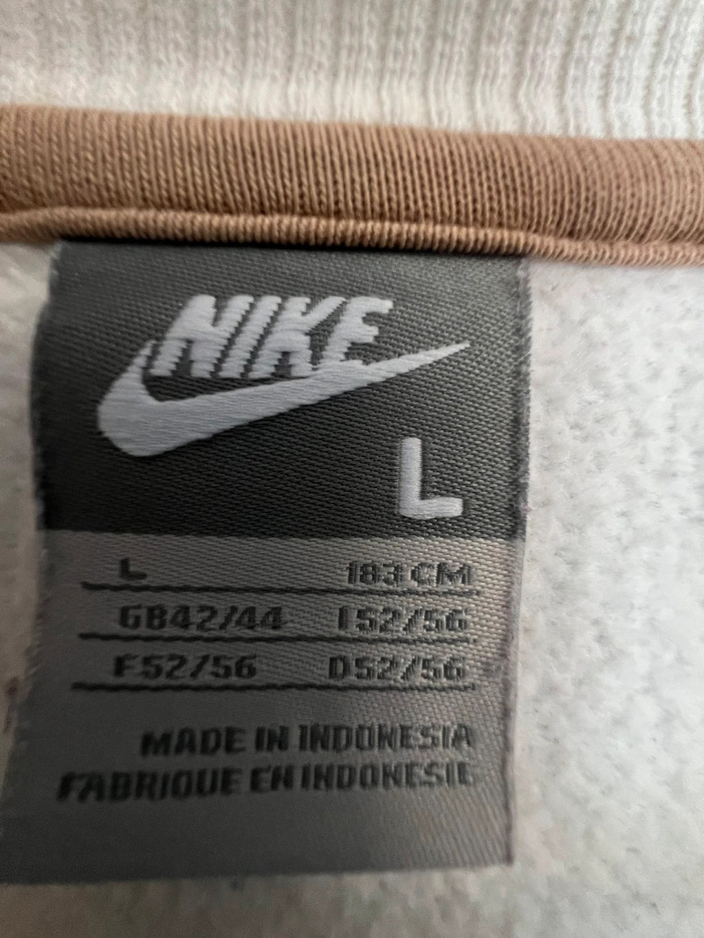 Nike white sweatshirt with beige embroidered logo and fleece interior.