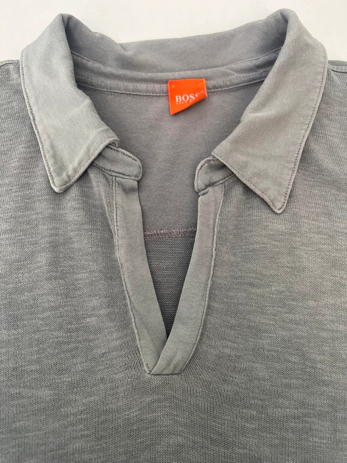 Hugo Boss grey long sleeve polo shirt with open collar and soft cotton fabric.
