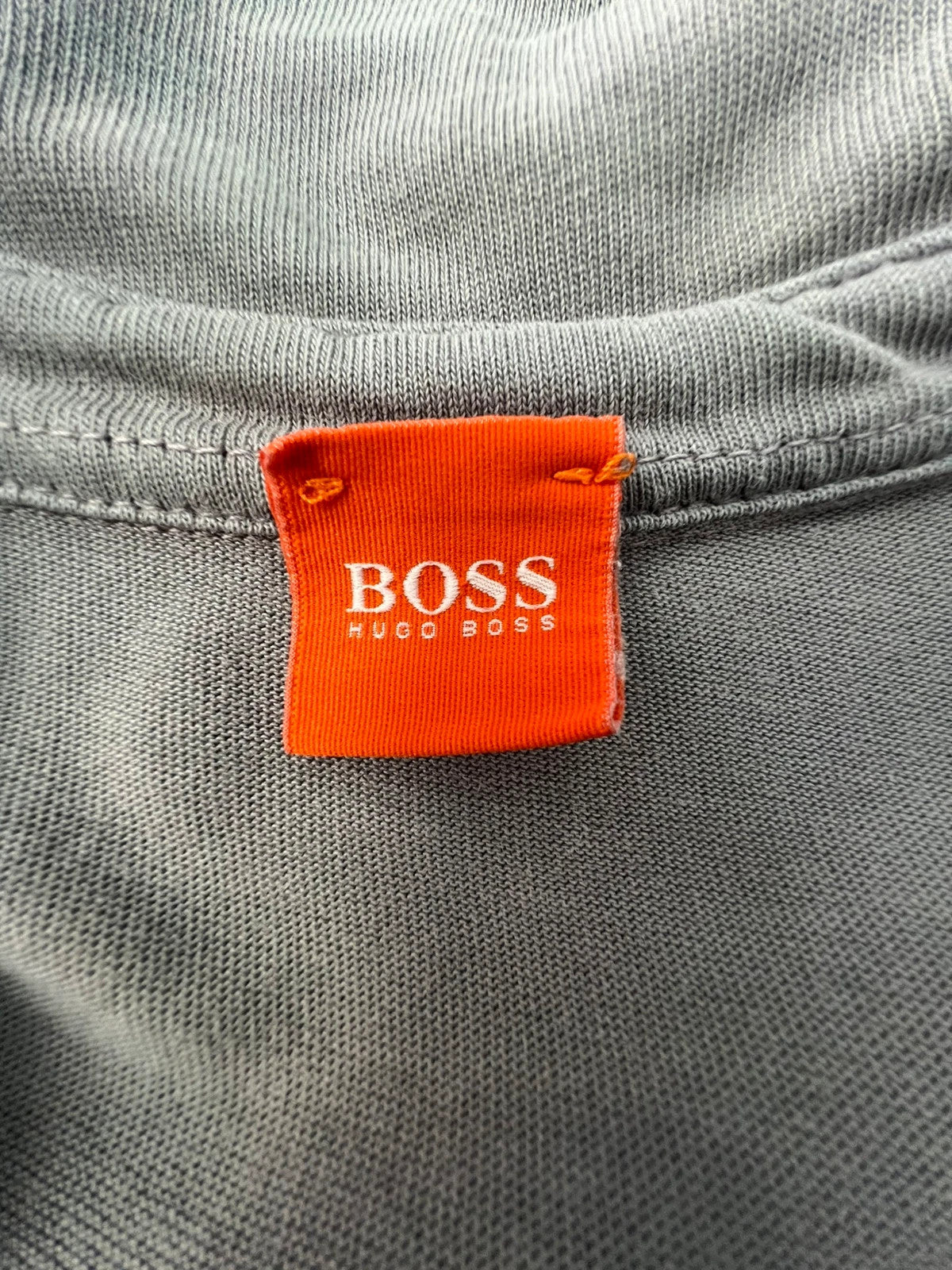 Hugo Boss grey long sleeve polo shirt with open collar and soft cotton fabric.