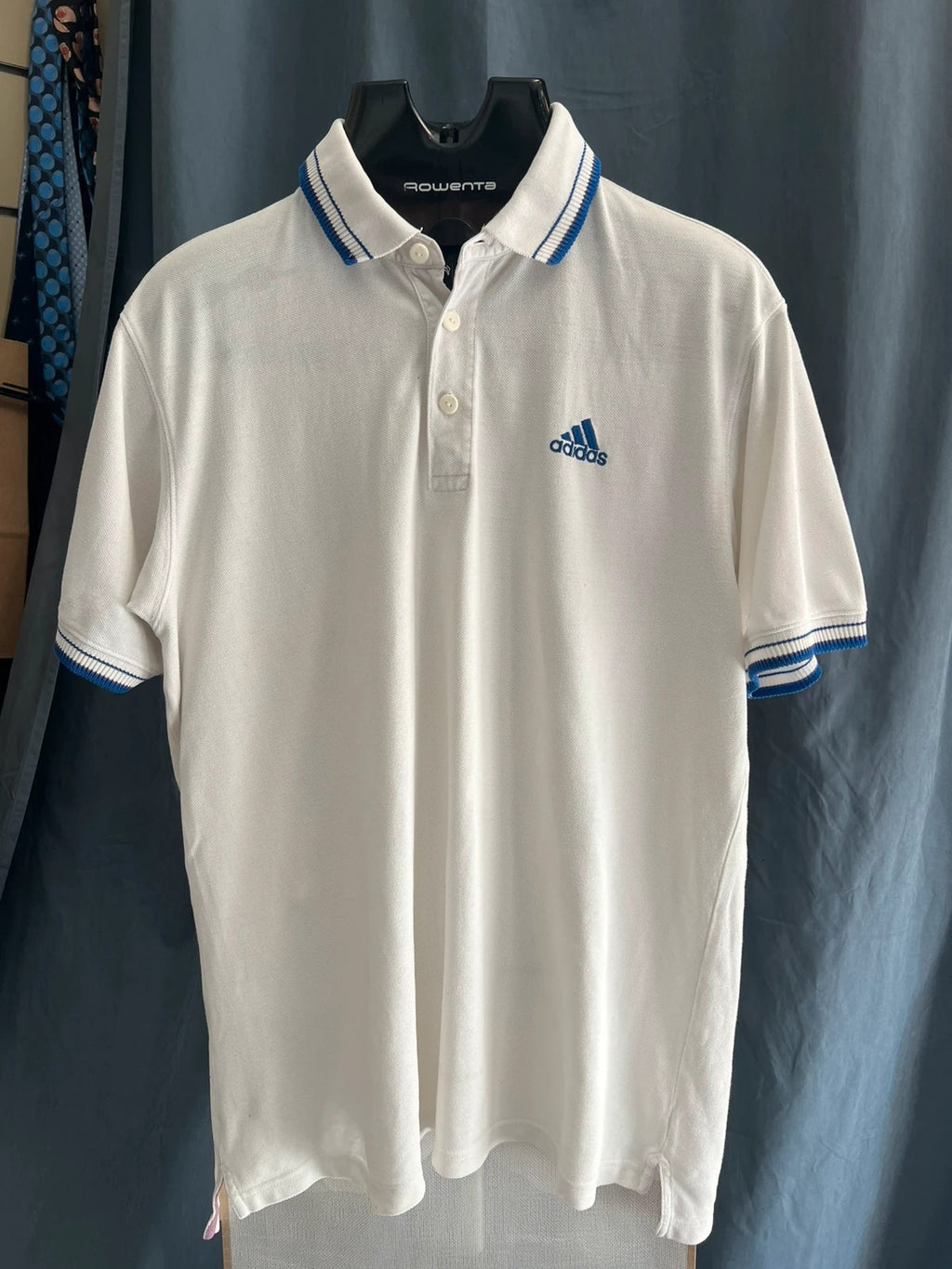 Adidas white polo shirt with embroidered blue logo, vintage Y2K style.