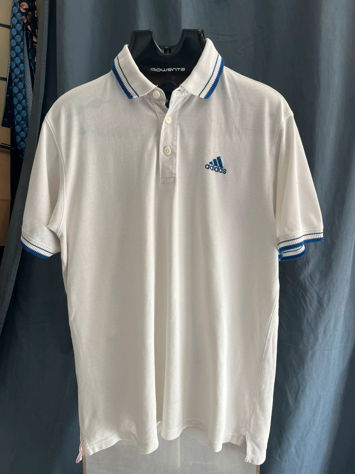 Adidas white polo shirt with embroidered blue logo, vintage Y2K style.
