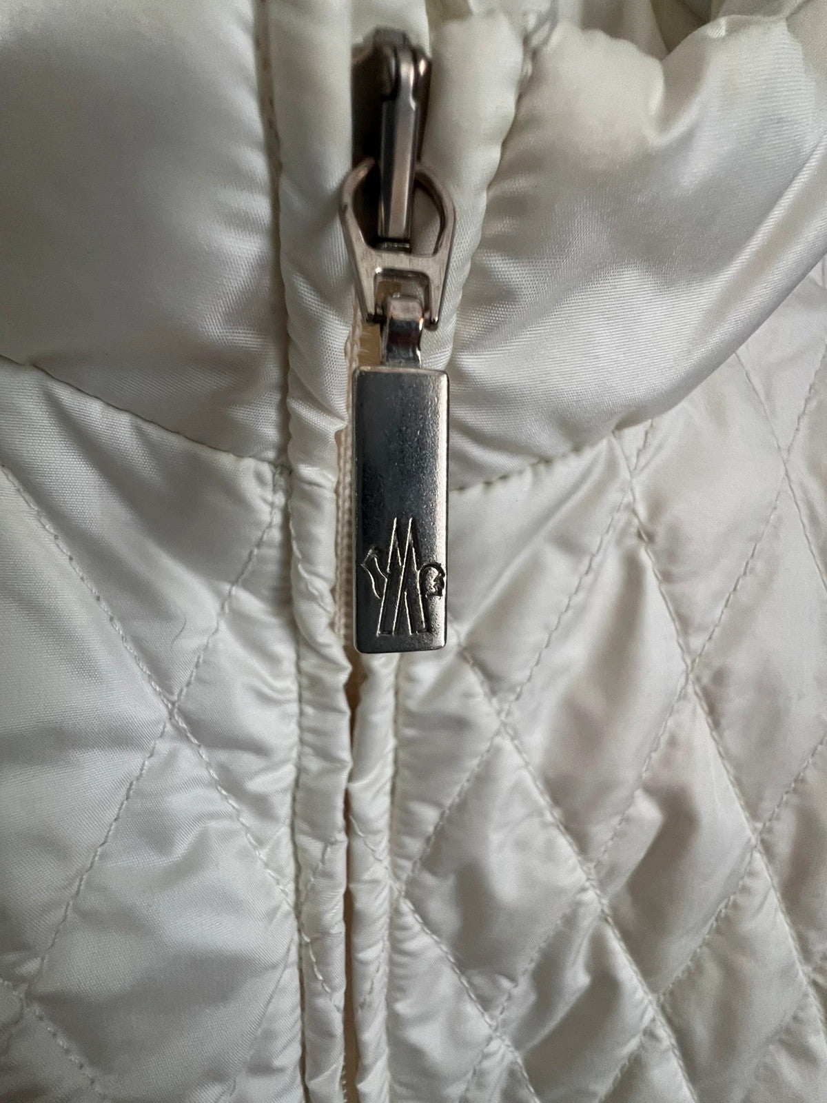 Moncler white gilet with diamond quilted pattern, high collar, and double zipper.
