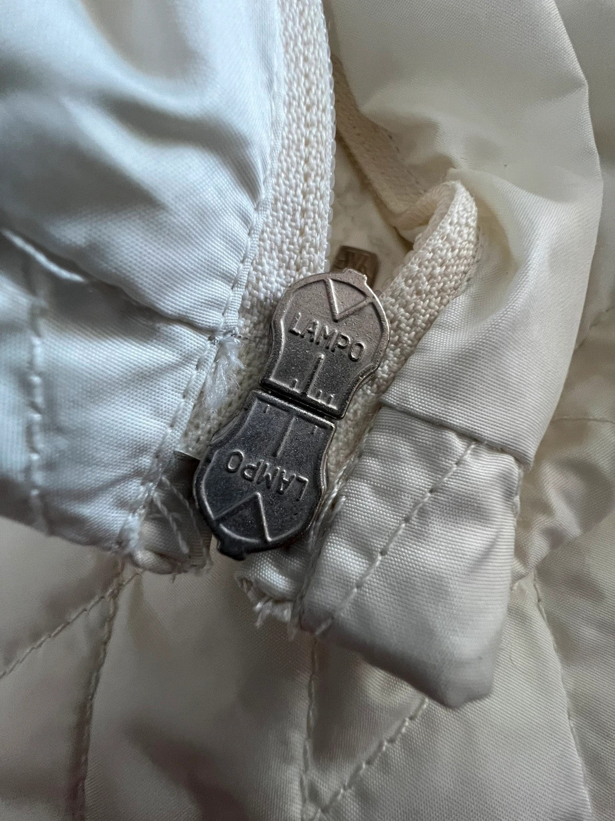 Moncler white gilet with diamond quilted pattern, high collar, and double zipper.